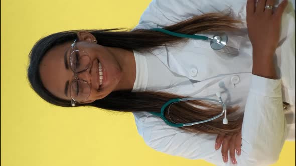 Portrait of African Female Doctor Smiling To the Camera on Yellow Background alt