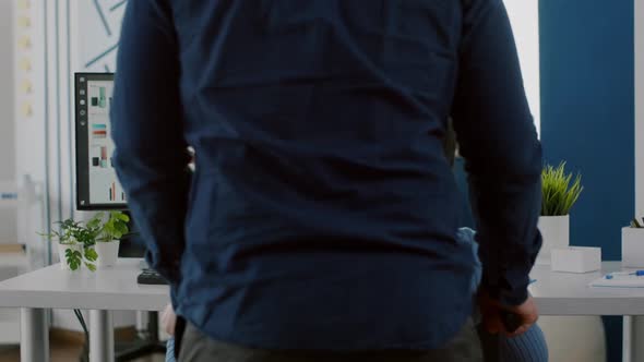 Man Employee Helping His Immobilized Black Colleague Entering in Office alt