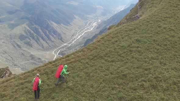 Aerial Shot of a Group of Tourists with Backpacks Climb the Mountain