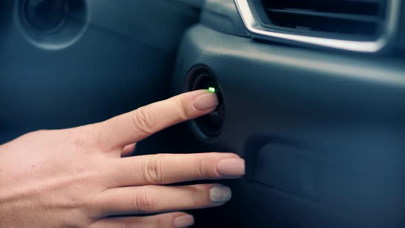 Woman Driver Hand Pushing Start Engine Button Motor In Car.Starting Car Engine.Car Power Ignition alt