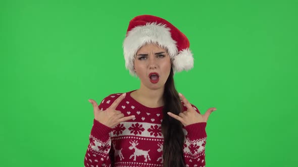 Portrait of Sweety Girl in Santa Claus Hat Is Making a Rock Gesture and Enjoying Life. Green Screen alt
