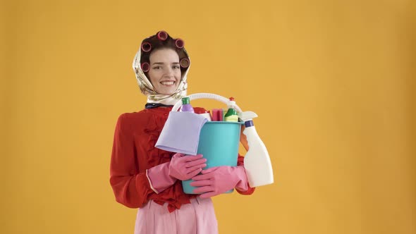 A Woman with a Bucket of Household Chemicals Smiles and Looks at the Camera