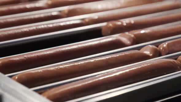 Hotdog Sausages Being Cooked on Grill on at Street Food Festival at Night. alt