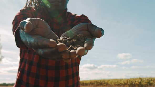 African Farmer Holding Soil in His Hands alt
