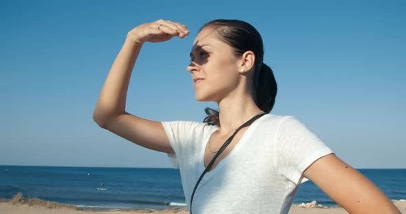 Young Attractive Woman Looking Forward with Blue Sky and Sea As Background alt