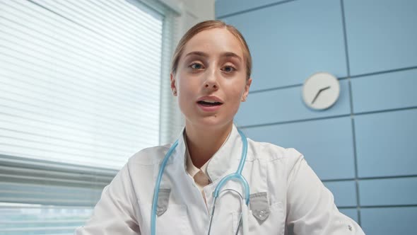 Smiling blonde young woman in white coat alt