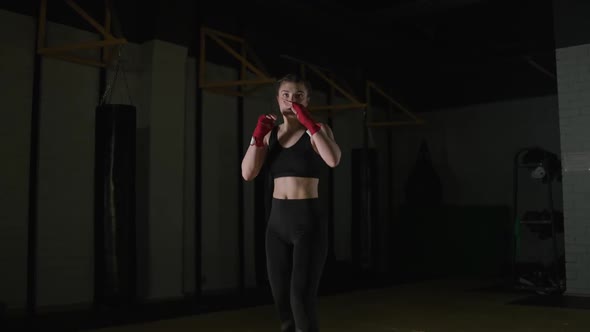 Female Fighter Trains His Kicks Training in the Boxing Gym Young Woman Looks at the Camera and alt