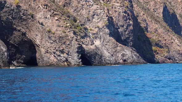 Lipari Island, Mountain with Caves in Mediterranean Sea. Summer Sunny Day, Blue Sky. Rippling Blue alt