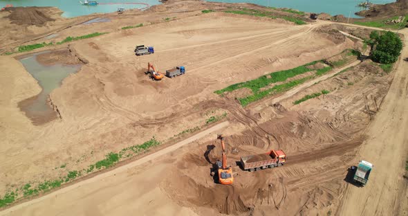 Excavators Loading Sand Onto Dump Trucks
