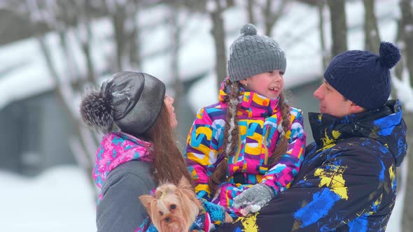 Careful Parents with Girl and Small Dog in Snowy Forest alt