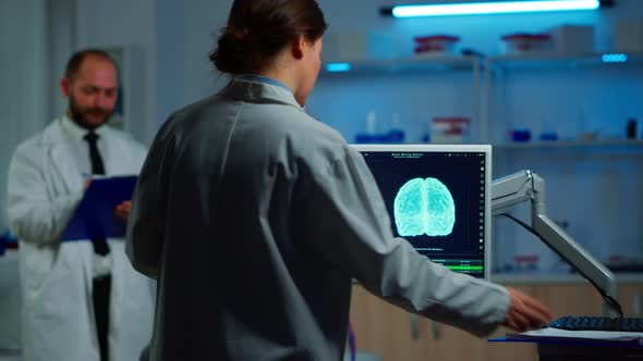 Researcher Looking at Monitor Analysing Brain Scan alt