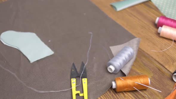 Scissors Cloth and Thread with Needles on Wooden Table