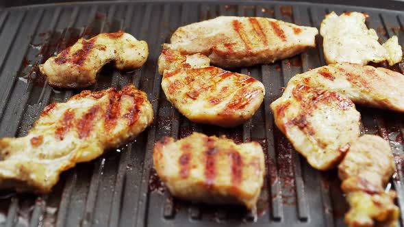 Close-up. Preparation of fried meat on the electric grill. Delicious pork. Beef alt