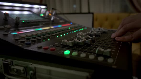 Close Up of Hand Sound Producer Using a Music Mixer with Editing Tools in Concert alt