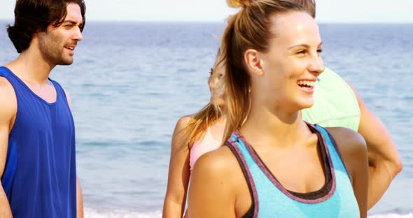Fit man and woman interacting with each other on the beach alt