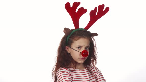 A Sweet Girl Dressed in a Toy Red Nose and Looks Very Resentful