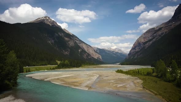 Cinematic drone shot over a bridge in a large mountain range. alt
