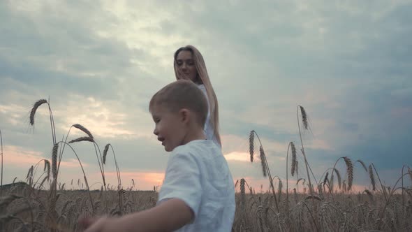 Young Cute Mother and Son in Wheat Field Countryside Nature Woman Enjoy Walks with Her Little Boy alt
