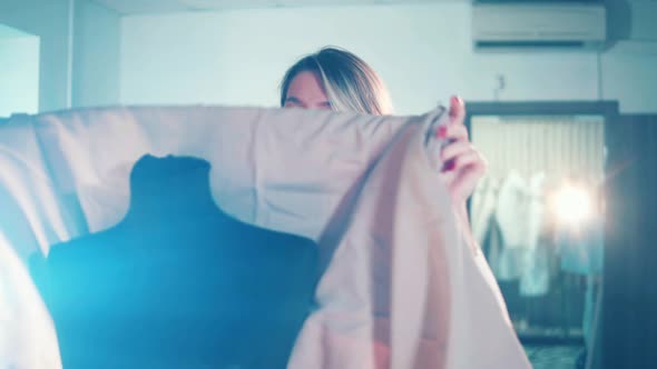 A Tailor is Putting a Piece of Clothes on a Dummy alt