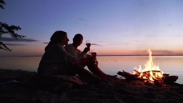 Girlfriends sitting near the campfire.