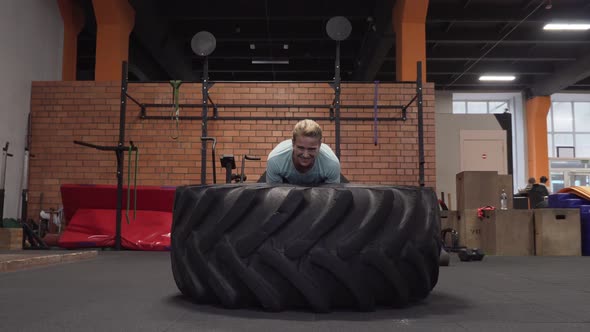 Fitness Woman Doing Big Tire Flips Workout at Gym