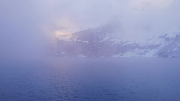 Oeschinensee Lake Switzerland Surrounded by Snow Covered Trees and Mountains alt