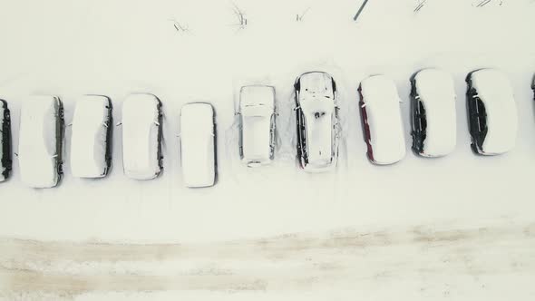 Cars in a Parking Lot Covered with White Snow After a Blizzard alt