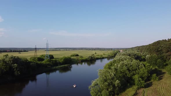 Drone flying over landscape with river and boat