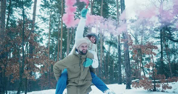 Wife Uses Pinkcolored Smoke Bomb Sitting on Husband Back alt