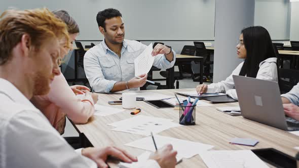 Young Confident Boss Discussing Details of New Startup with Diverse Colleagues Sitting at Table in alt