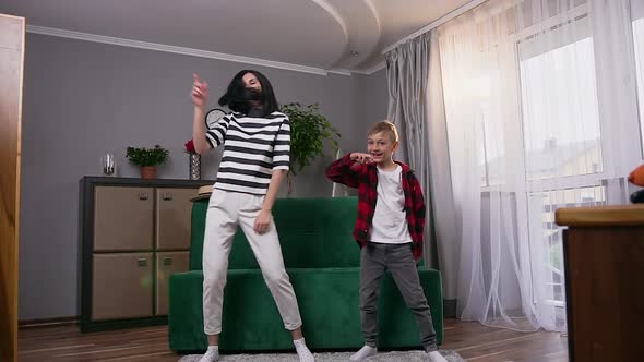 Mother and Son which Having Fun Together and Making Dancing Disco Movements at Home alt