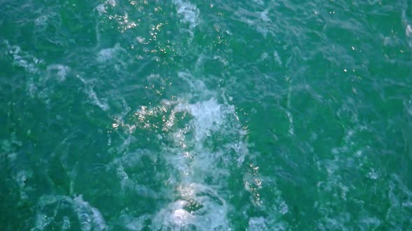 Wave pattern on water surface formed after forward moving boat. Full screen. alt