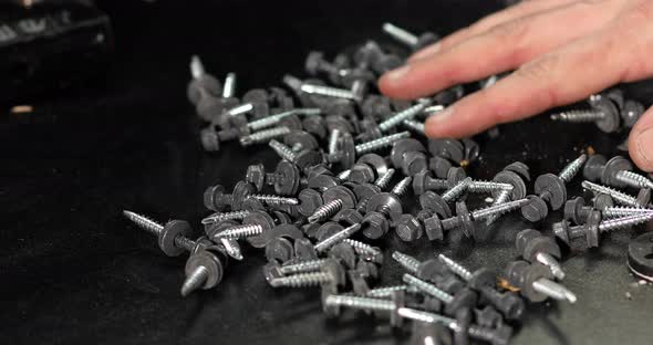 Man hands take in handful Roofing self-tapping screws
