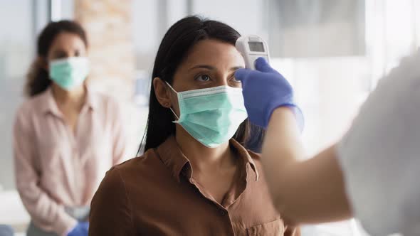 Video of employees going through mandatory temperature checks in office. alt