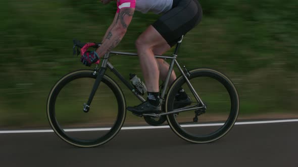 Tracking shot of a male cyclist on country road.  Fully released for commercial use.