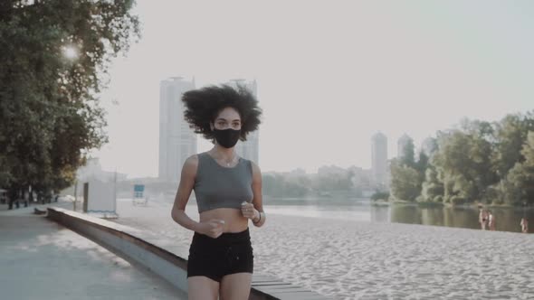Attractive Slim Girl Wearing a Medical Mask Stretching Her Legs Near the River alt