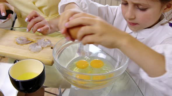 Little Helper Cooking with Mother, Girl Breaks Eggs Into Bowl. Simple Kids Meals