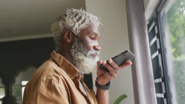 Video of african american senior man using smartphone alt