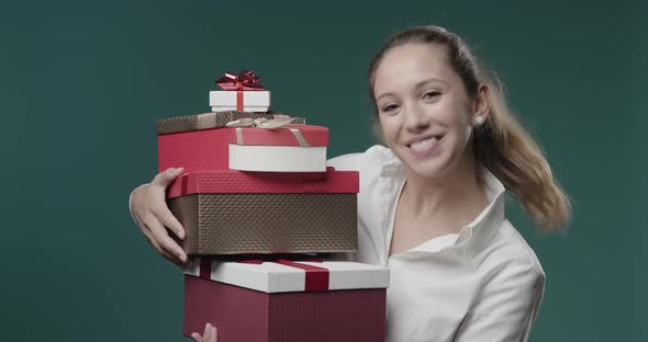 Happy young woman holding a lot of gift boxes, Christmas shopping and celebration concept
