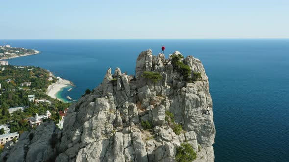 Aerial View of Man Travel Tourist Standing the Top Rock Enjoying Diva Rock and Seascape in Simeiz alt