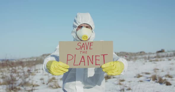 Man Wore in White Full Cover Suit Shows Protest Sign Save the Planet in Winter alt