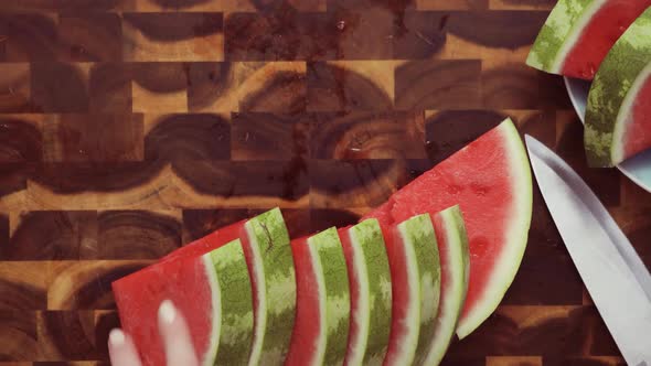 Step by step. Top view. Slicing red watermelon on a wood cutting board. alt