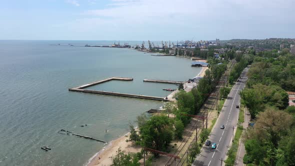 Seaside in the city. You can see the beach, roadway and seaport.