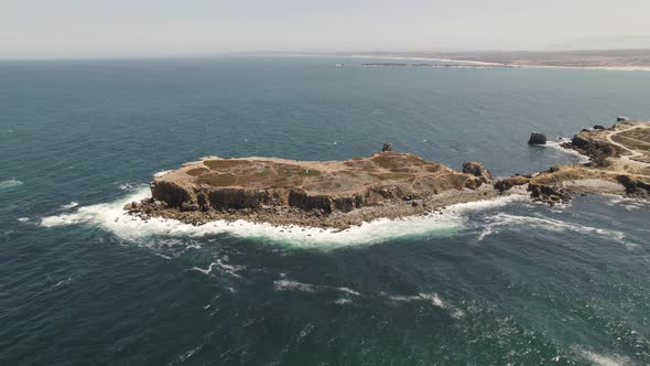Drone pan revealing Papôa scenic spot, rocky peninsula; Peniche, Portugal