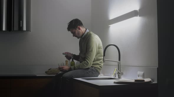 Man Using Smartphone And Drinking Wine alt