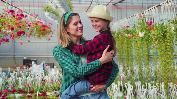 Happy Gardeners Family Kid Girl with Her Mother Mother Holding Her Daughter in Her Arms alt
