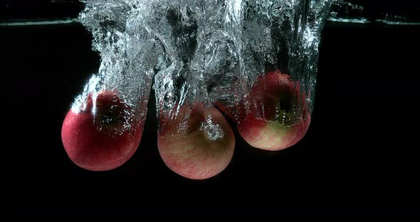 900458 Apples, malus domestica, Fruits entering Water against Black Background, Slow Motion 4K alt