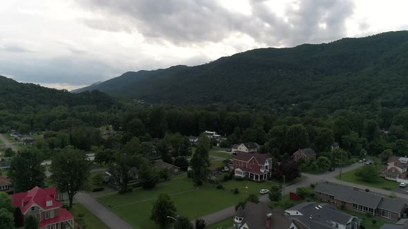 A slow forward aerial establishing shot flying over homes and houses in the Virginia hills. alt