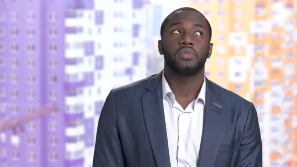 Thoughtful Afro-american Businessman on Blurred Background. alt