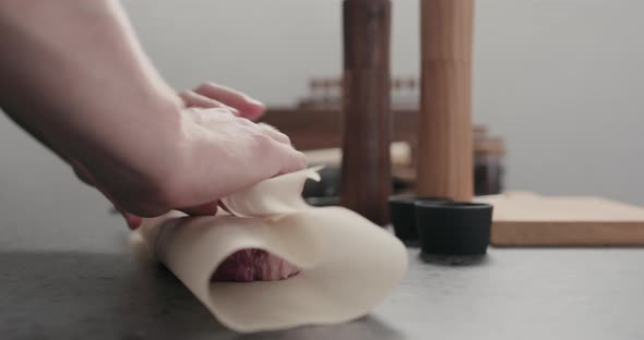 Slow Motion Man Wrap New York Steak on Countertop alt